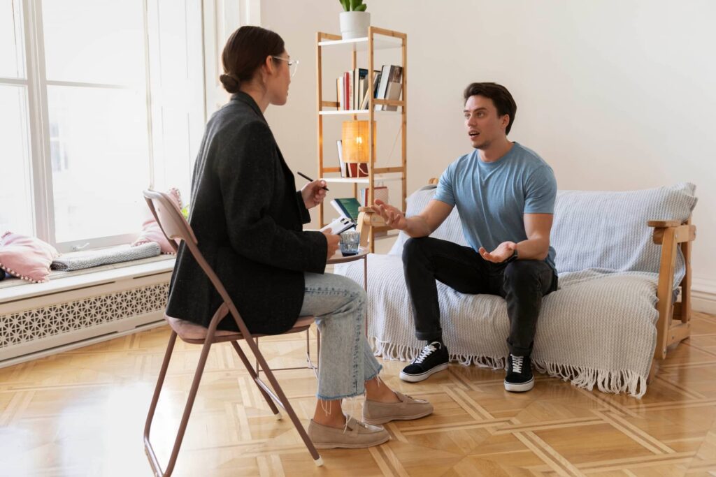 A man and woman sitting on a couch in a living room.